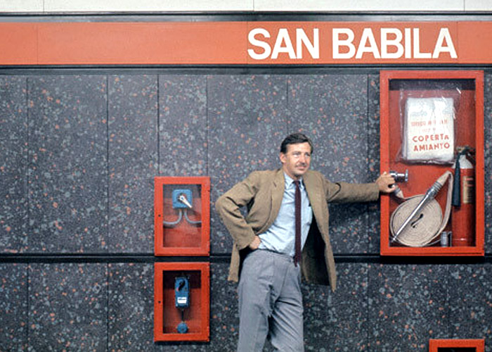 Bob Noorda in front of signage, designed by him, of Milan Metro